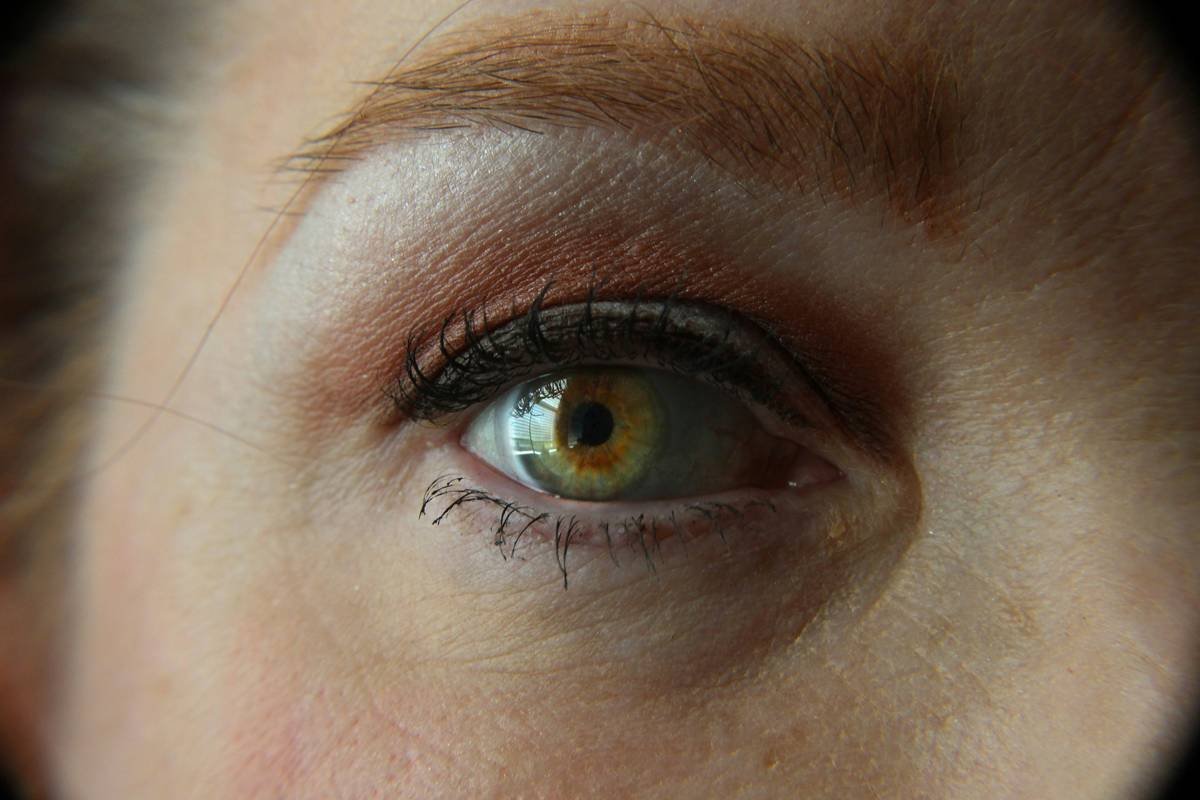 Competitor applying beauty contest prep makeup under stage lights