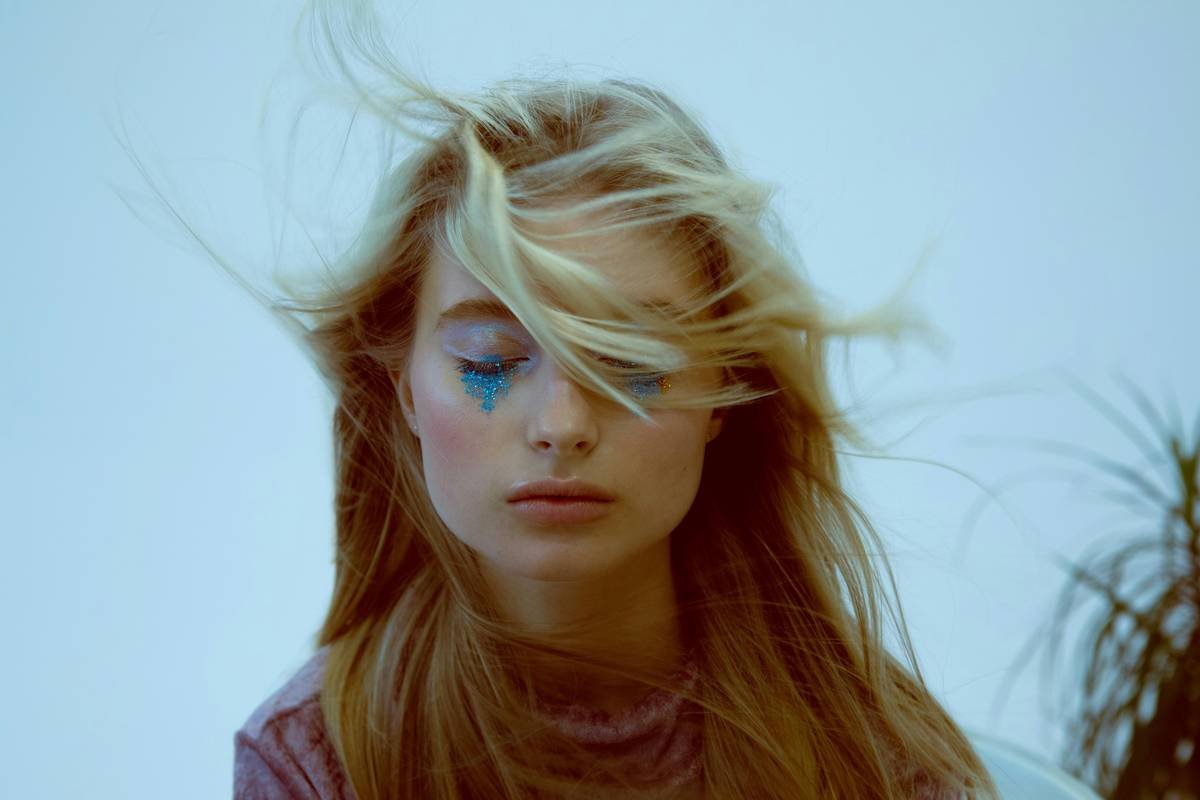 Behind-the-scenes shot of fantasy makeup ideas being applied using mixed media on a model’s face